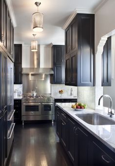 a kitchen with black cabinets and stainless steel appliances