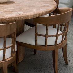 a wooden table with white chairs around it