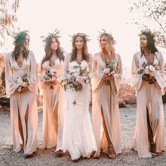 a group of women standing next to each other wearing long dresses and holding bouquets