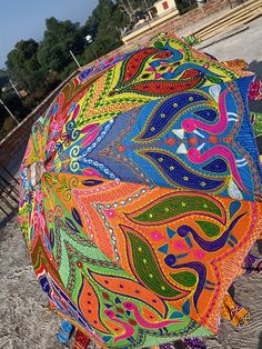 an umbrella is decorated with colorful designs on it