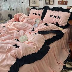 a bed with pink sheets and black bows on it