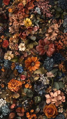 a bunch of flowers that are on the ground in front of a wall with many different colors