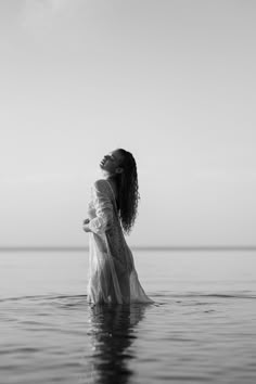 a woman is standing in the water with her eyes closed