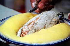 a person is cutting into some food on a blue and white plate with powdered sugar