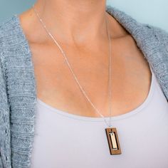 "This rectangular bar necklace offers the boldness of a geometric design combined with the delicacy of a long, slender composition. The outer rectangle encompasses an inner panel for a multi-faceted design with movement and visual interest. Two tones of intricately cut wood - walnut and maple - give additional texture to the piece. Wood and silver necklaces can be dressed up or down, making them the perfect complement to any outfit! Pair with the matching rectangle earrings for a coordinated loo Modern Rectangular Necklace, Modern Everyday Necklace, Inspirational Keychains, Laser Cut Necklace, Rectangle Necklace, Faceted Design, Rectangle Earrings, Bespoke Gifts, Printed Jewelry