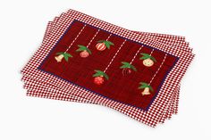 three placemats on top of each other with fruit embroidered onto the sides, sitting next to each other