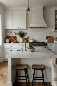 a kitchen with two stools in front of an island