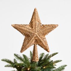 a wicker star ornament hanging from a christmas tree