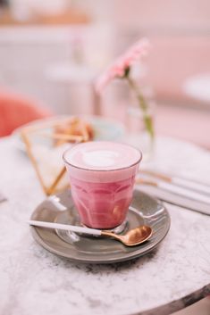 a cup and saucer sitting on top of a plate with spoons next to it