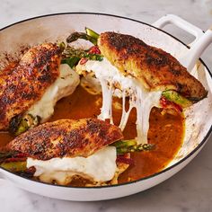 a pan filled with chicken and vegetables covered in sauce on top of a white counter