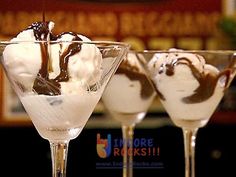 three martini glasses filled with ice cream and chocolate toppings on a bar counter top