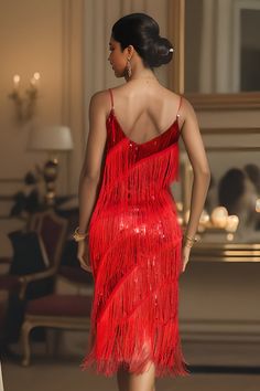 a woman in a red dress is walking down the runway with her back to the camera