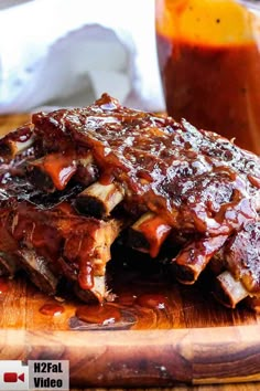 slow cooker baby back ribs on a cutting board with bbq sauce in the background