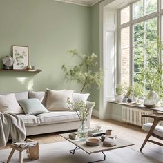 a living room with green walls and white furniture