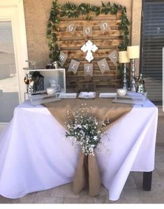 the table is set up with white linens and burlocks on it, along with some baby's breath flowers