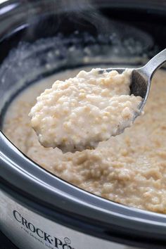 a spoon full of oatmeal in an electric crock pot with the lid open