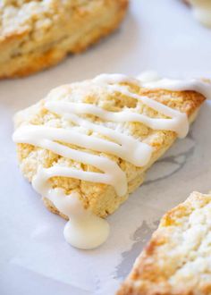 scones with icing sitting on top of white paper