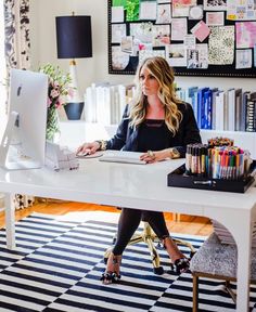 a woman sitting at a desk in front of a computer