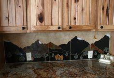 a kitchen counter top with wooden cabinets and granite tiles on the backsplash area