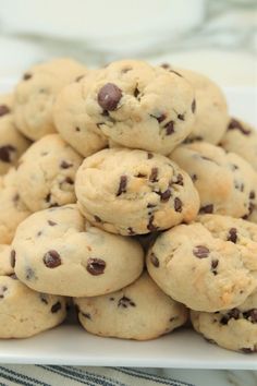 a pile of chocolate chip cookies sitting on top of a white plate