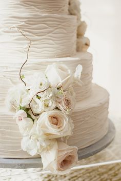 a wedding cake with white flowers on top