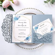 an elegant wedding suite with blue flowers on the front and back, sitting on a plate