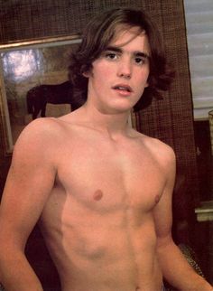 a shirtless young man standing in front of a mirror with his hands on his hips