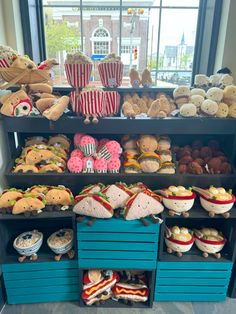 a display case filled with lots of different types of foods and pastries in front of a window