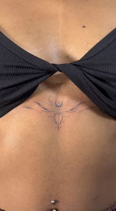 a woman's stomach with a tattoo on her side and the bottom part of her belly