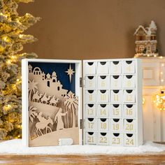 an open christmas card with nativity scene and trees in the background