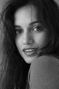 a black and white photo of a woman with long dark hair smiling at the camera