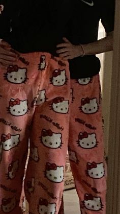 a woman in hello kitty pajamas is holding her stomach