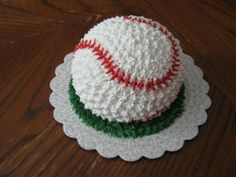 a cake that is sitting on top of a doily with a baseball on it