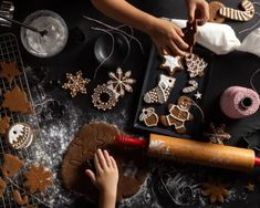 two children are decorating christmas cookies on a table