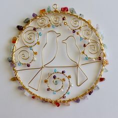 a gold plate with two birds on it, surrounded by multicolored glass beads