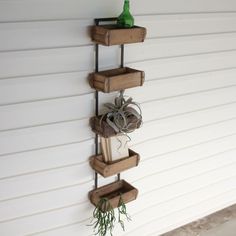 three wooden boxes are hanging on the wall with some books and other things in them