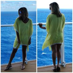 a woman standing on the deck of a cruise ship looking out at the ocean while wearing a yellow dress