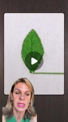 a woman is standing in front of a screen with an image of a green leaf on it