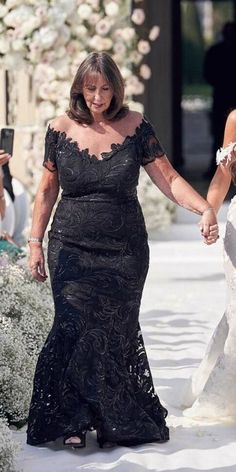 two women walking down the aisle holding hands