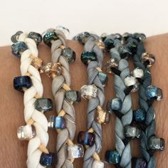 several different bracelets on someone's arm with glass beads and silver metal clasps