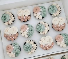 twelve cupcakes in a box with frosting and flowers on them, all decorated to look like seashells