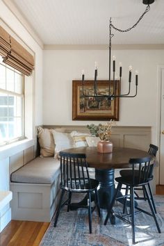 a dining room table with four chairs and a bench in front of the couches