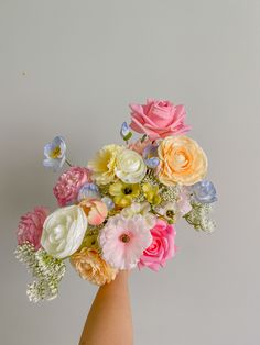 a person's hand holding a bouquet of flowers