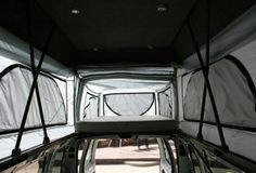 the inside of a vehicle with its door open and windows partially covered in tarp