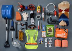 an assortment of items laid out on top of a gray surface, including gloves, safety vest and other items