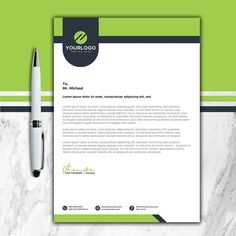 a green and black letterhead with a pen next to it on a marble surface