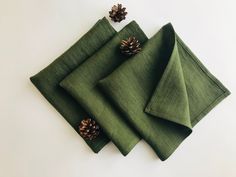 three green napkins with pine cones on them