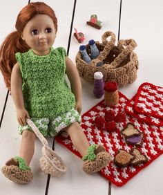 a doll sitting on the floor next to some crocheted items