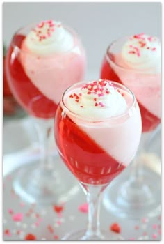 three glasses filled with red and white desserts next to confetti sprinkles