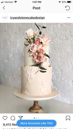 a white and pink wedding cake with flowers on top